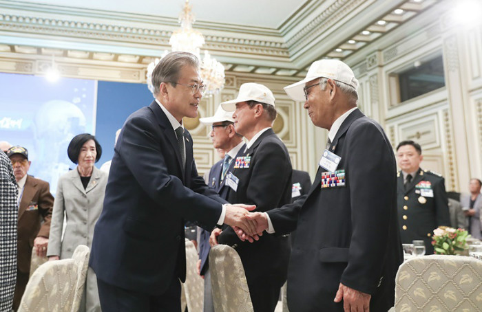 President Moon Jae-in on June 24 shakes hands with Korean War veterans in a luncheon he hosted for them at Cheong Wa Dae.